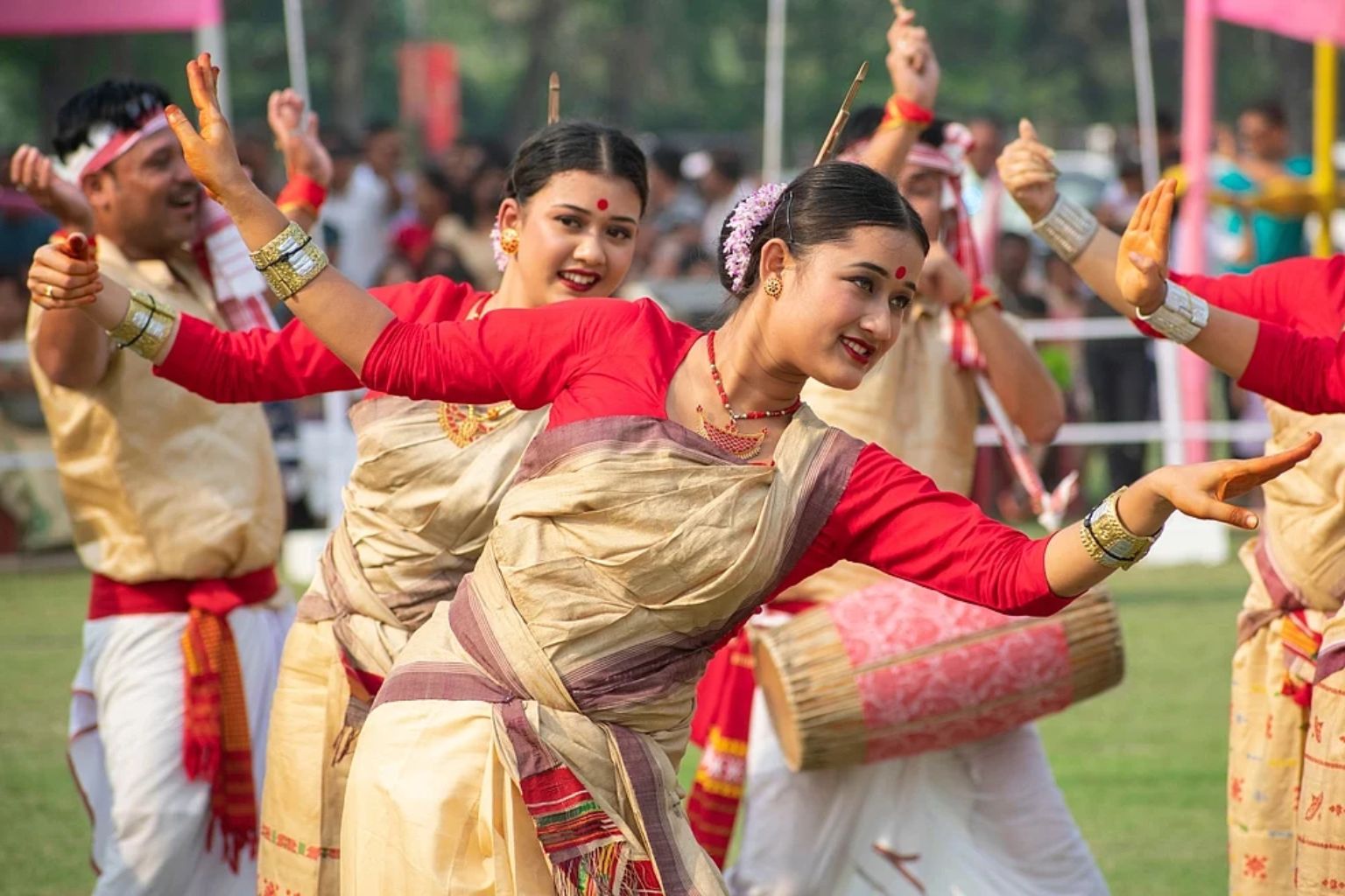 Bihu dancers of Assam in traditional mekhela chador performing with a dhol player