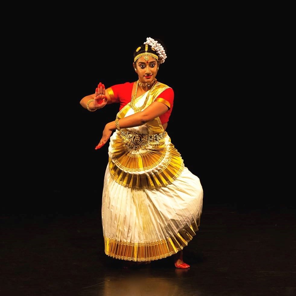 Mohiniyattam dancer in traditional white and gold Kasavu costume performing gracefully