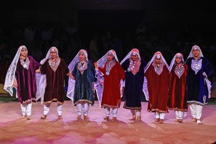 Professional Rouf dancers in traditional pheran costumes with Kashmiri embroidery